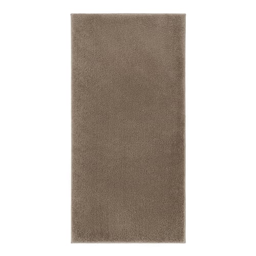 A rectangular, beige BACKMÅRA bath mat with a soft, shaggy texture and latex backing, designed to absorb water and keep its place in the bathroom.