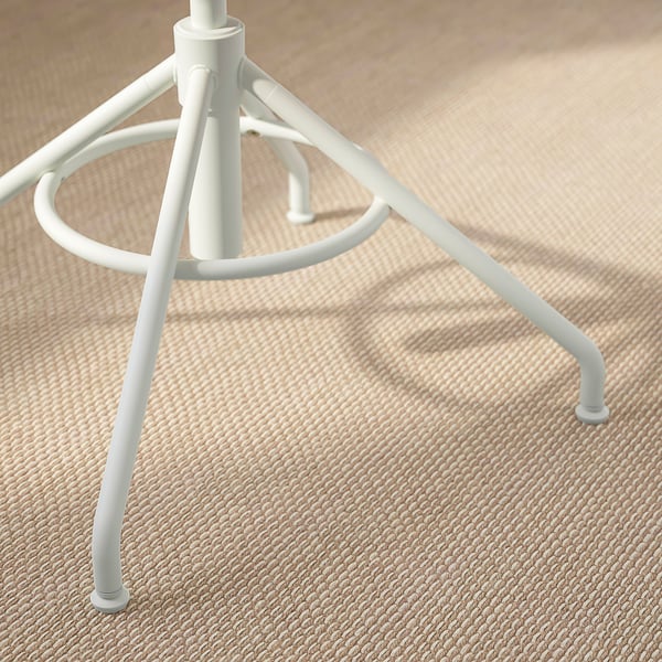 Close-up of white metal chair leg with textured floor. Sturdy, minimal design.