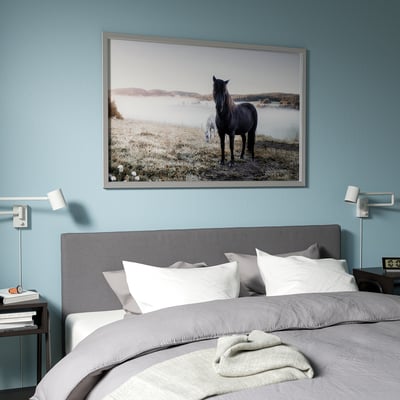 Silver aluminium canvas frame by andreas stridsberg on blue wall.