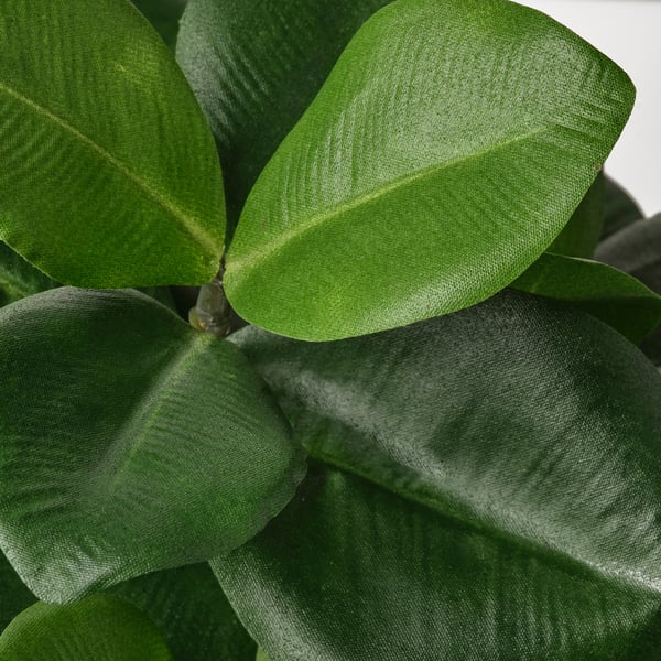 Close-up of lifelike artificial leaves, vibrant green and textured, arranged naturally.