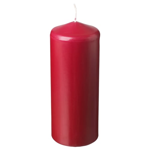 A red FENOMEN candle. It is cylindrical in shape and made from plant-based and paraffin wax with a cotton wick. Ideal for creating a warm atmosphere.