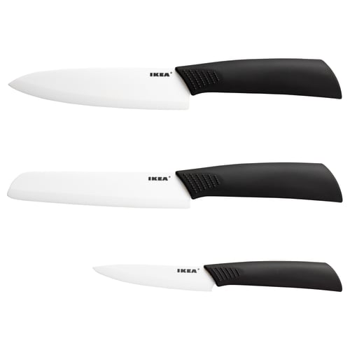 Three ceramic knives by ikea in black handles, sharp blades, arranged neatly.