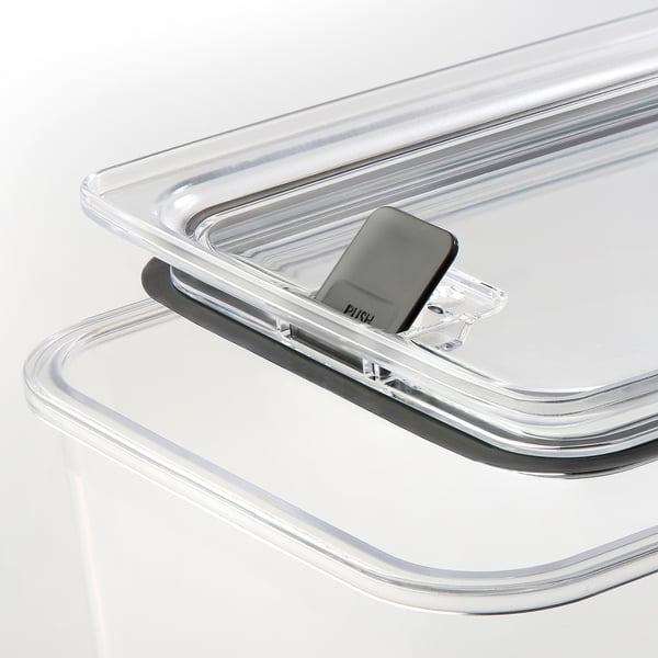 Clear stackable food jar lid, sealed with ventilation button, resting on jar, transparent for easy viewing.