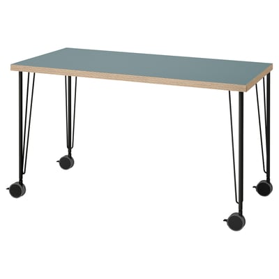 A LAGKAPTEN desk with a blue top and wooden edges, supported by black metal legs with wheels.