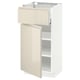 A white and beige IKEA METOD kitchen cabinet with a drawer and shelves, featuring a modern high-gloss finish and sleek handles.