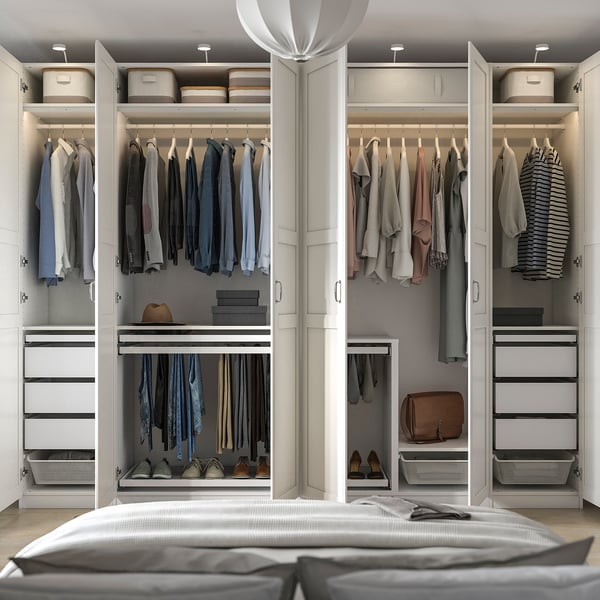 Modern walk-in closet with clothes hangers, drawers, and shelves, featuring lighting, jewellery trays, and a unity of organised storage.