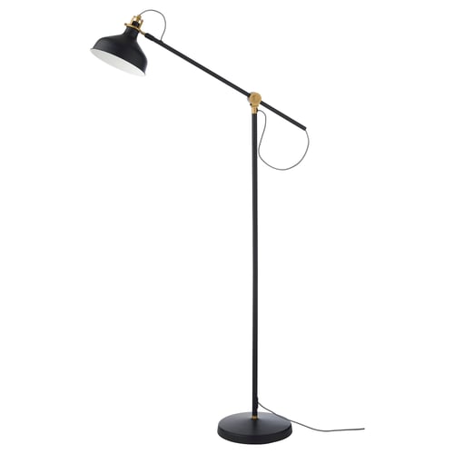 RANARP lamp, black with gold accents. Adjustable arm and head, standing on round base. Modern, industrial design.