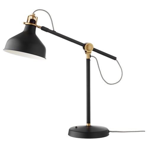 A black and brass RANARP desk lamp with an adjustable arm and shade. It offers directional lighting for tasks.