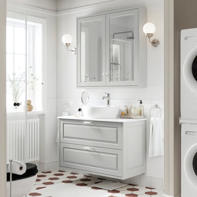 Modern bathroom: sleek grey vanity, white sink, mirror cabinet, patterned floor, white washer.