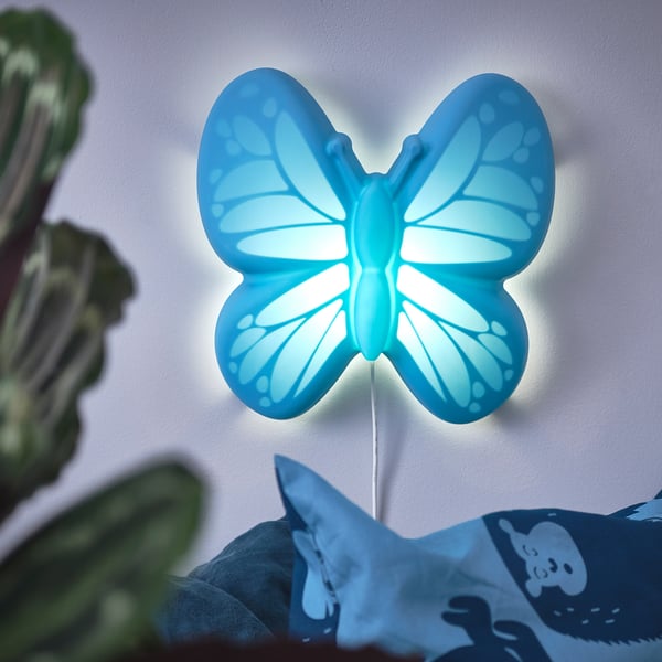 Bright blue butterfly night light on wall, made of recycled plastic, emits soft glow.