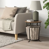 Angelsby Beistelltisch neben dem Sofa, rustikalem Holz und Metall, Aufbewahrungstasche aus Stoff, Lampe und Büchern.