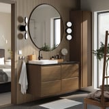 Modernes Badezimmer: runder Spiegel, Waschtisch aus Eiche, Marmorwaschbecken, Wandmontage, Pflanze, Handtücher, Korb, gemusterter Boden, Bett dahinter.