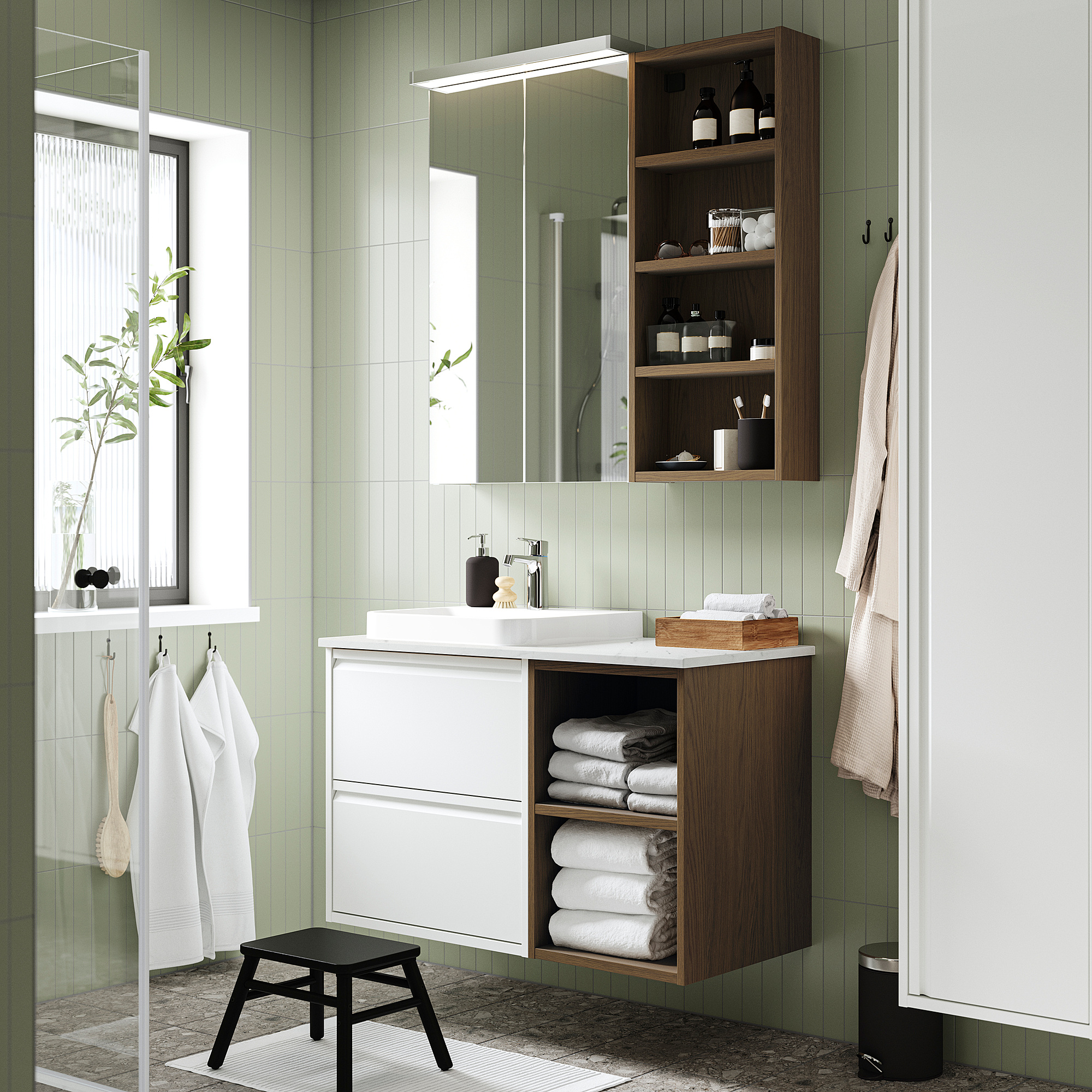 Modernes grünes Badezimmer mit weißem Waschbecken, Holzregalen und hängenden Handtüchern.