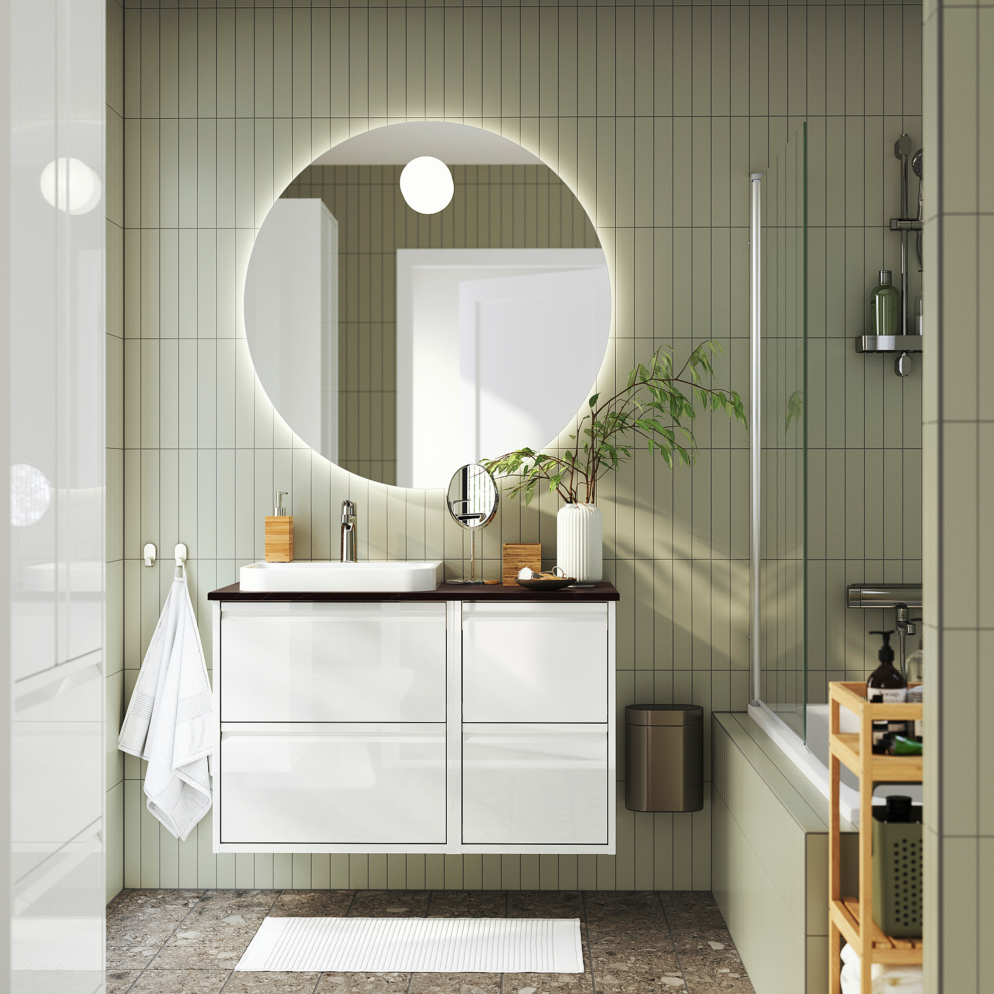 Modernes Badezimmer mit ÄNGSJÖN-Waschtisch, Spiegel, Dusche, Handtuch, Pflanzen- und Aufbewahrungsregal.