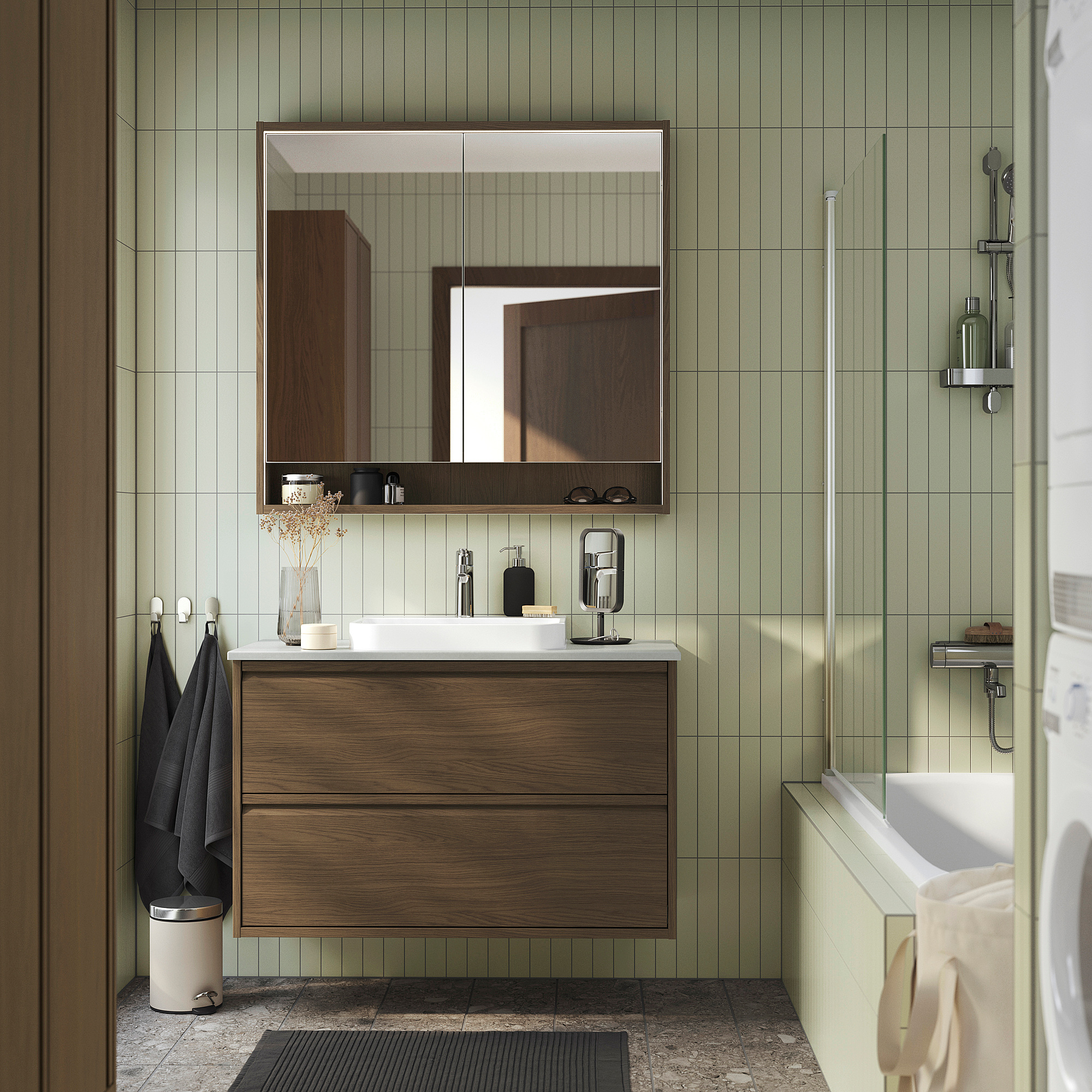 Modernes Badezimmer ÄNGSJÖN Schrank in brauner Eichenoptik mit Waschbecken aus weißem Marmor, großem Spiegel und Glasdusche. Schlankes, minimalistisches Design.