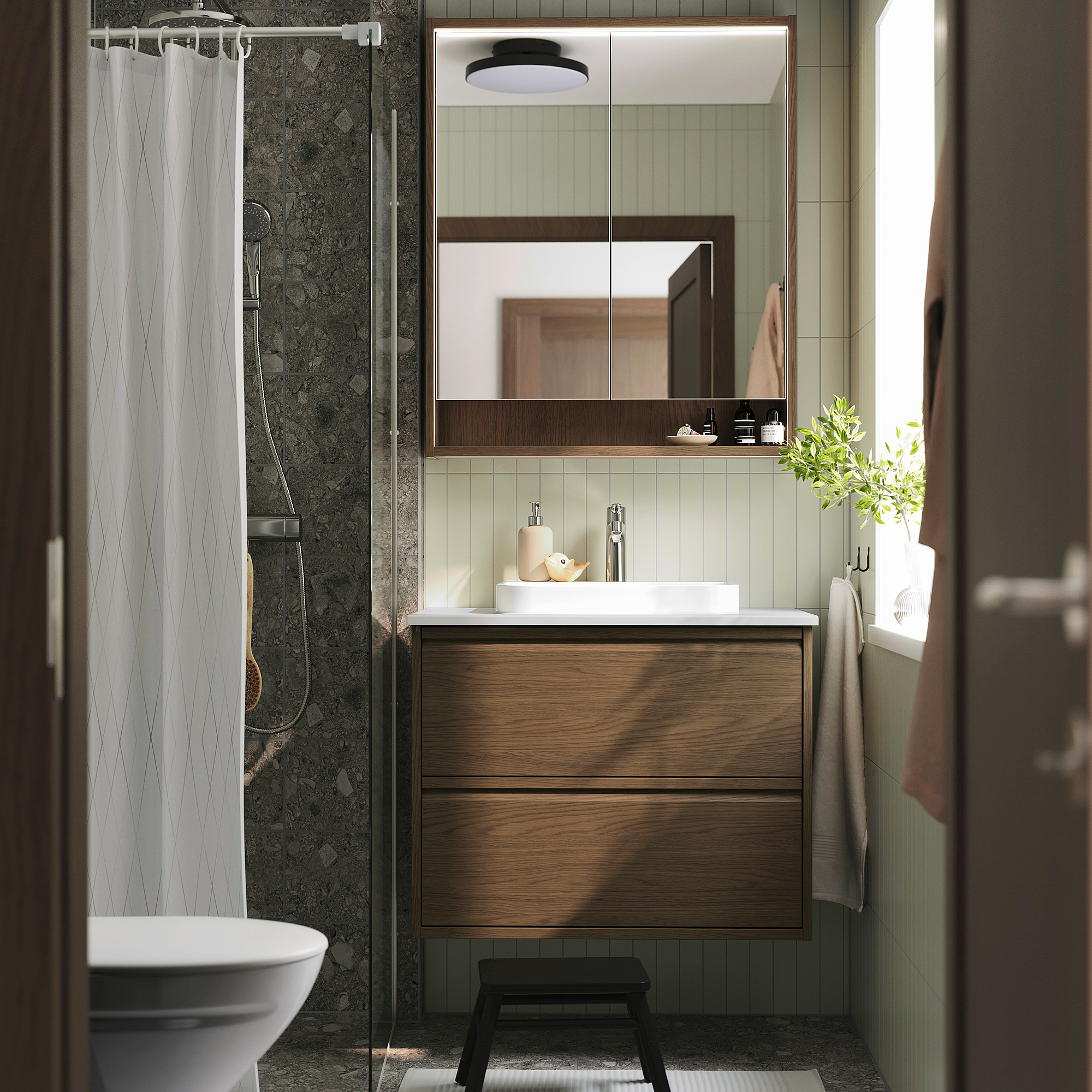 Modernes Badezimmer mit Waschtisch aus brauner Eiche, Marmorwaschbecken, großem Spiegel und Duschvorhang. Schwarzer Hocker vorne.