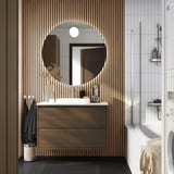 Modernes Badezimmer mit ÄNGSJÖN-Waschtisch aus dunklem Holz, rundem Spiegel, weißer Arbeitsplatte und schwarzen Akzenten.