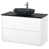 Ein moderner weißer Waschtisch mit einem dunkelgrauen Waschbecken aus Glas. Der Schrank hat zwei Schubladen und ein schlankes, minimalistisches Design.