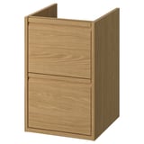 Ein hellbrauner Badezimmerschrank aus Holz mit silbernen Griffen, zwei Schubladen und einer Arbeitsplatte.