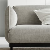 Ein modernes graues Sofa, ÄPPLARYD, mit schlanken schwarzen Beinen, weichen Kissen und minimalistischem Design.