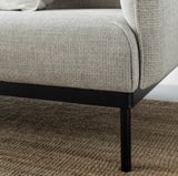 Modernes hellgraues Sofa, schlanke schwarze Metallbeine, gemütliche Kissen.