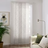 Weiße Vorhänge mit Blattmuster sorgen für ein helles, ruhiges Ambiente. Hergestellt aus recyceltem Polyester, bodenlang. Das Zimmer verfügt über eine Couch, Kissen und eine hohe Pflanze.