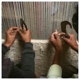 Hände, die einen Wollteppich auf einem Webstuhl weben, wodurch ein kompliziertes Muster entsteht. Traditionelles Handwerk im Gange.
