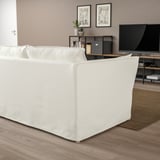 Modernes Wohnzimmer: weißes BACKSÄLEN Sofa, groß auf hellem Holzboden, mit TV und Regalen dahinter.