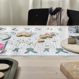 Backmatte mit Ausstechformen und Streuseln auf einem Tisch, die lustige Formen und Matheübungen zeigt.