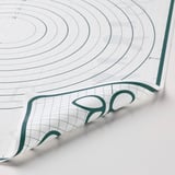 Große Backmatte mit grünem Rand und Gittermustern. Zeigt sowohl kreisförmige als auch quadratische Designs für präzises Backen.