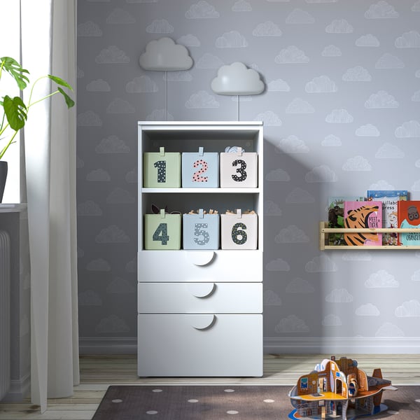 Kinderzimmer mit Wolkenwänden, Aufbewahrungsschrank, Teppich, Bücherregal, Spielzeug, Vorhang, Heizkörper, Pflanze.