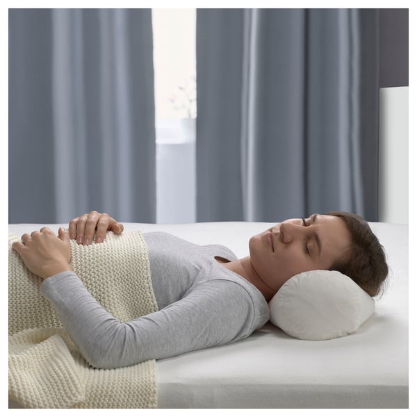 Eine Person, die ein BARRBERBERIS Nackenkissen auf einem Bett benutzt. Das Kissen ist weiß, besteht aus Baumwolle und Entenfedern und hat ein klassisches Design für die Nackenstütze.