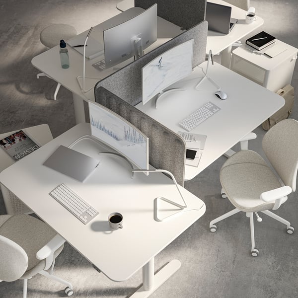 Moderne weiße Büroeinrichtung: Schreibtische mit Bildschirmen, Computern, Stühlen und Lampen im minimalistischen Stil.