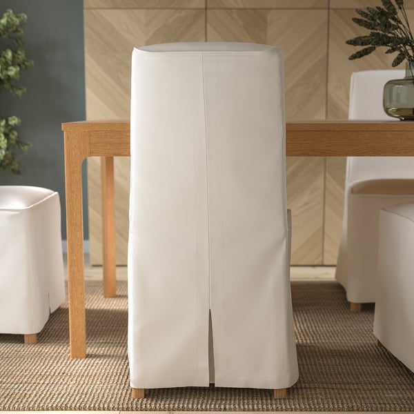 Ein moderner Essbereich mit weißen Polsterstühlen mit abnehmbaren, waschbaren Bezügen von BERGMUND, Holzbeinen und ergonomischem Design.