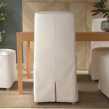 Ein moderner Essbereich mit weißen Polsterstühlen mit abnehmbaren, waschbaren Bezügen von BERGMUND, Holzbeinen und ergonomischem Design.