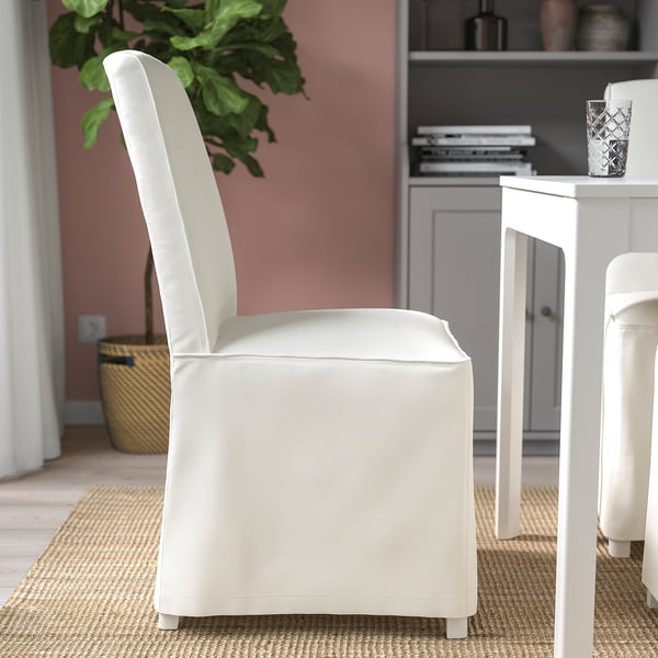 Weißer gepolsterter Stuhl mit hoher Rückenlehne und Beinen aus Massivholz, ideal für bequemes Sitzen.