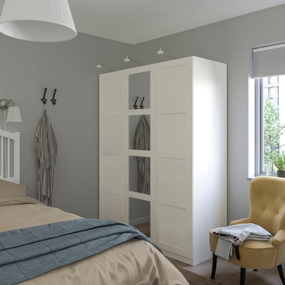 Modernes Schlafzimmer mit BERGSBO Kleiderschrank, Spiegeltür, hellem Holz, hoch, neben dem Bett, gemütliche Ecke.