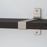 Modernes Wandregal mit gebürsteten Metallhalterungen, die sicher an einer weißen Wand befestigt sind. Das Regal hat schlanke, abgeschrägte Kanten und eine dunkle Holzoberfläche.