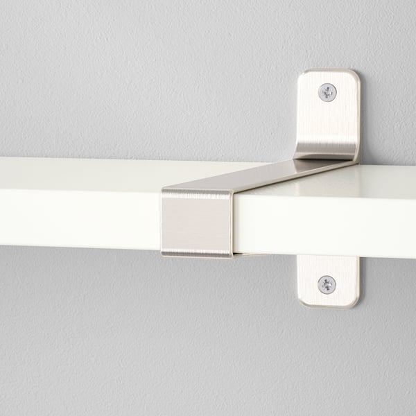 Robuste Wandregalhalterungen aus Metall, die sicher an der beigen Wand befestigt sind und ein modernes, weißes Regal mit sauberen, abgerundeten Kanten tragen.