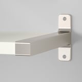 Moderne Metallhalterung, die mit Schrauben sicher an der Wand befestigt wird und ein schlankes Wandregal aus Metall trägt.