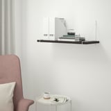 Modernes schwarzes Regal BERGSHULT an weißer Wand, kleiner als Stuhl, mit Dekor.