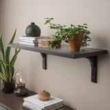 Wandregal mit Büchern, Pflanzen und Dekoration. Hält Gegenstände sicher, ideal für Schlafzimmer oder Wohnzimmer.