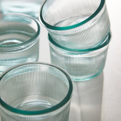Vier grüne Becher aus recyceltem Glas mit Welligkeitsdesign, breiter und niedriger Form; BERGVATTNET von hanna-kaarina heikkilä.