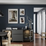 Moderner Essbereich mit dunkelgrauem BESTÅ-Stauraum, weißen Stühlen und gerahmter Kunst auf dunkelblauer Wand.