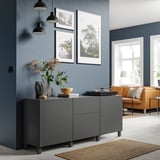 Modernes Wohnzimmer mit einem grauen BESTÅ-Stauraum mit Hängelampen, gerahmten Kunstwerken, Trockenblumen und einer orangefarbenen Couch.