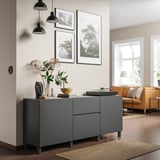 Modernes Wohnzimmer mit grauem BESTÅ-Stauraum, orangefarbenem Sofa und Hängelampen.