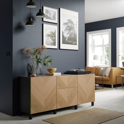 Modernes Wohnzimmer mit BESTÅ Sideboard, Pflanzen, Lampen, Kunst, orangefarbenem Sofa, Teppich.