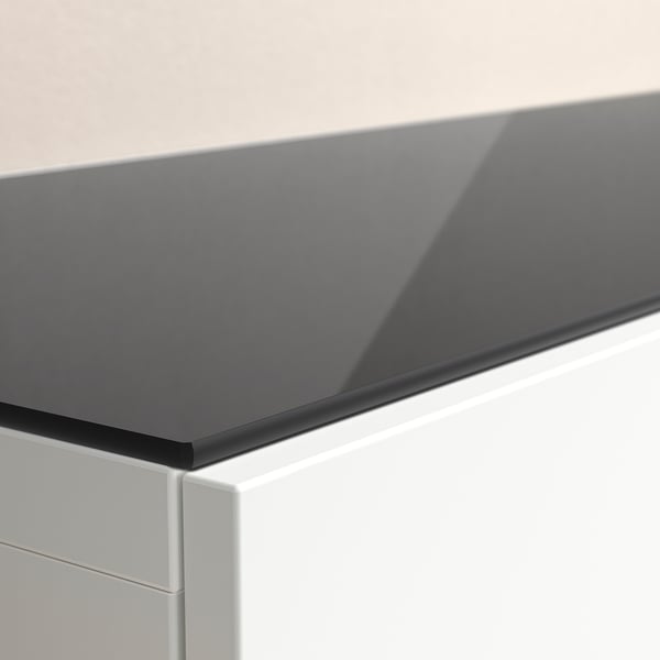 Moderne graue Glastischplatte auf schlankem, weißem Schrank. Glatte Oberfläche und schlanke Kanten.