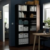 Bücherregal mit verstellbaren Regalen und offenem und geschlossenem Stauraum, in dem organisierte Gegenstände ausgestellt werden.