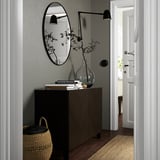 Moderner Eingangsbereich mit BESTÅ Sideboard, Spiegel, Leuchten, Vase und Korb.